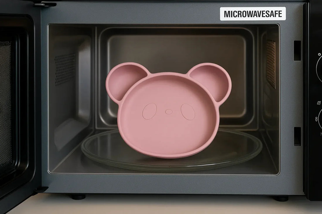 Assiette bébé en silicone rose en forme d’ours placée dans un micro-ondes, certifiée micro-ondes safe avec intérieur en inox.
