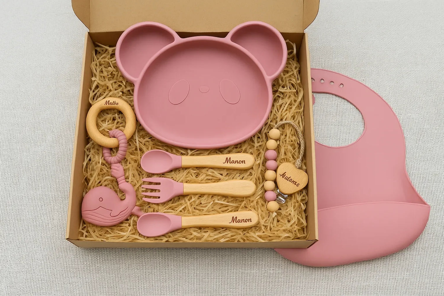 Coffret cadeau de naissance personnalisé avec assiette panda, couverts gravés, attache-tétine, anneau de dentition et bavoir rose en silicone.