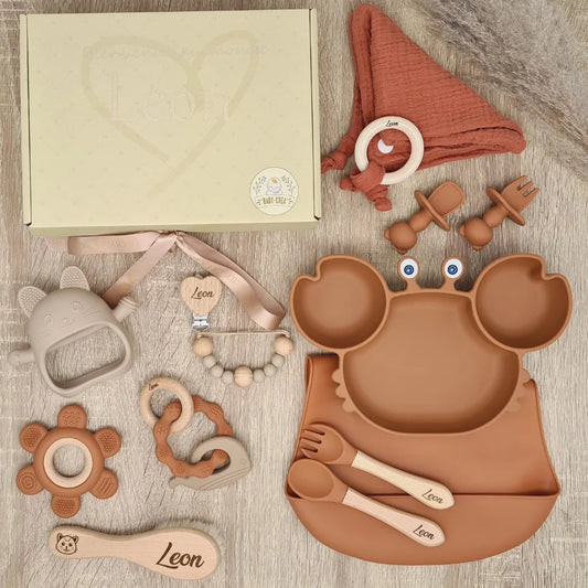 Coffret naissance personnalisé au prénom Leon, couleur rouge tommette, incluant assiette crabe ventouse, bavoir silicone et accessoires d'éveil en bois.