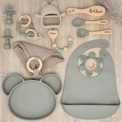 Ensemble de naissance en tons gris, comprenant un plateau en forme de panda, des couverts, une sucette et un jouet, tous personnalisés avec le nom Arthur.