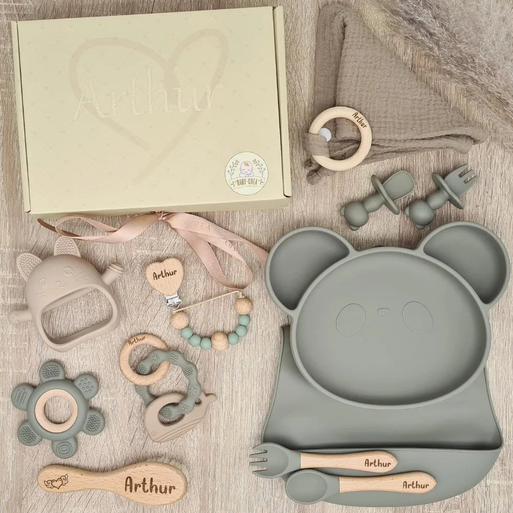 Coffret de naissance avec un plateau en forme de panda et divers accessoires pour bébé, tous en couleur grise, personnalisés avec le nom Arthur.