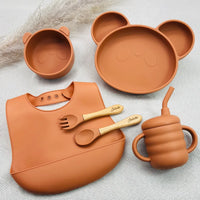Coffret naissance bébé terracotta complet : vaisselle silicone personnalisée, assiette panda, tasse, bavoir et couverts bois.