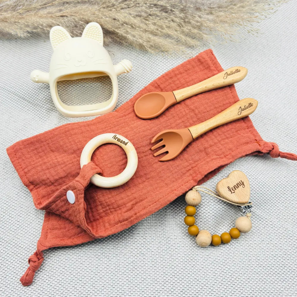 Coffret repas bébé terracotta personnalisé avec lange, couverts gravés Juliette, attache tétine prénom Lenny, anneau de dentition bois prénom Armand, jouet dentition chat crème – idée cadeau de naissance.