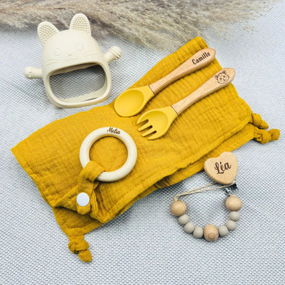 Ensemble repas bébé moutarde avec lange, couverts gravés Camille, attache tétine prénom Léa, anneau de dentition prénom Melia, jouet de dentition chat crème – coffret naissance personnalisé tendance.