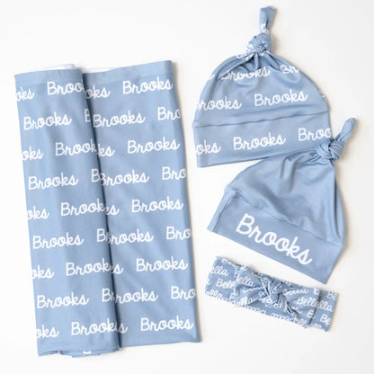 Set emmaillotage complet 2026 Bleu Ciel avec bonnet personnalisé.