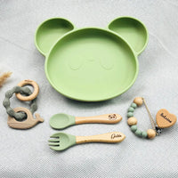 Vaisselle bébé verte personnalisée avec prénom gravé, couverts bois silicone, hochet baleine et attache tétine cœur.