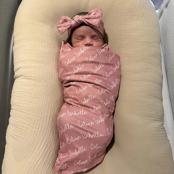 Bébé endormi dans une couverture d'emmaillotage rose