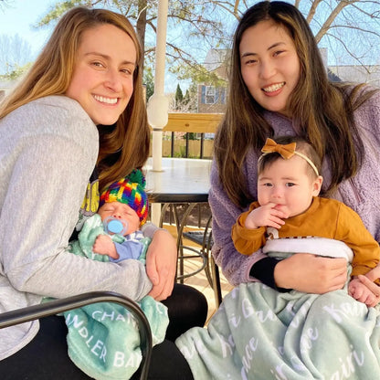Idée photo naissance : bébé endormi enroulé dans un plaid personnalisé vert menthe sur un tabouret. Couverture souple et chaude pour séance photo nouveau-né.